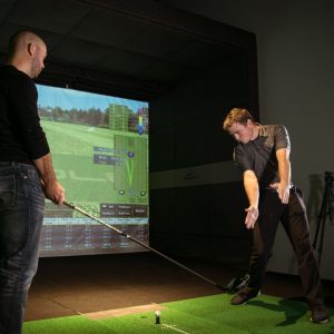Instructor helping a golfer with their swing.